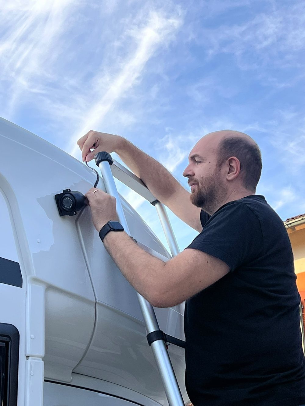 Montaggio di una telecamera sulla fiancata alta di un camper, con il cavo fatto passare lungo il profilo